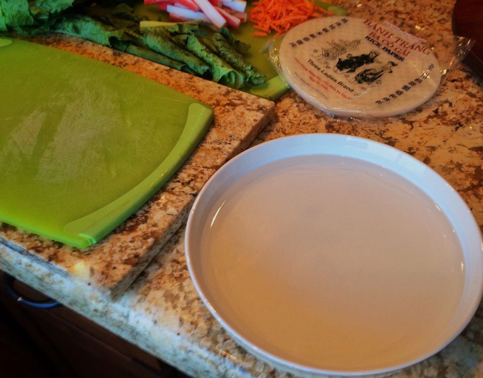 In very warm water, soften one piece of rice paper at a time by holding the paper in the water for at least 1 minute.