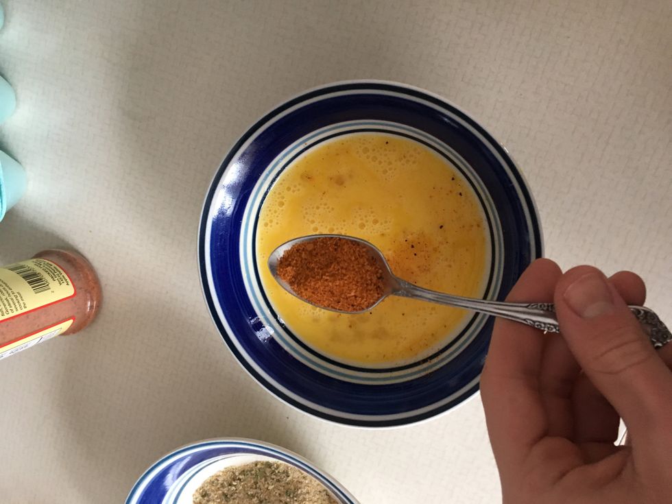 In your second bowl crack two eggs and whisk them. Then take a seasoning of your choice and add 3 tablespoons to the whisked eggs and mix it in.