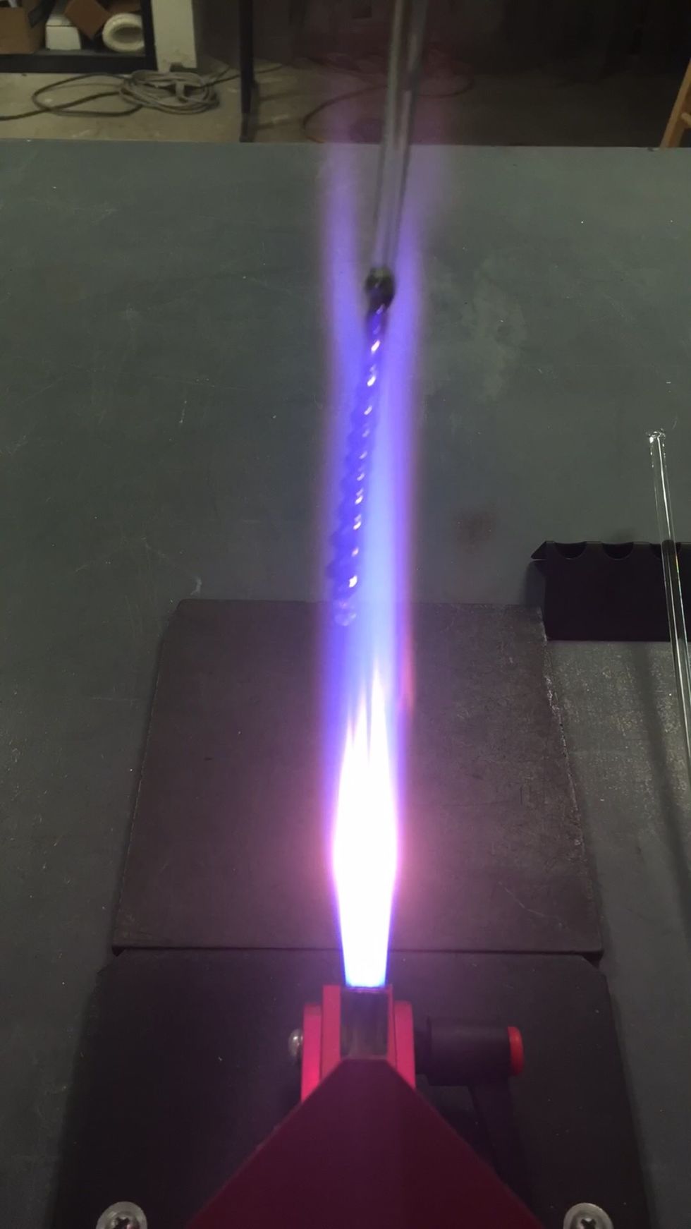 Increase your propane a bit to create a reduction flame. Pass the icicle through the top of the flame. Repeat as needed to achieve a metallic shine. Keep it cool to prevent droop and over-reduction