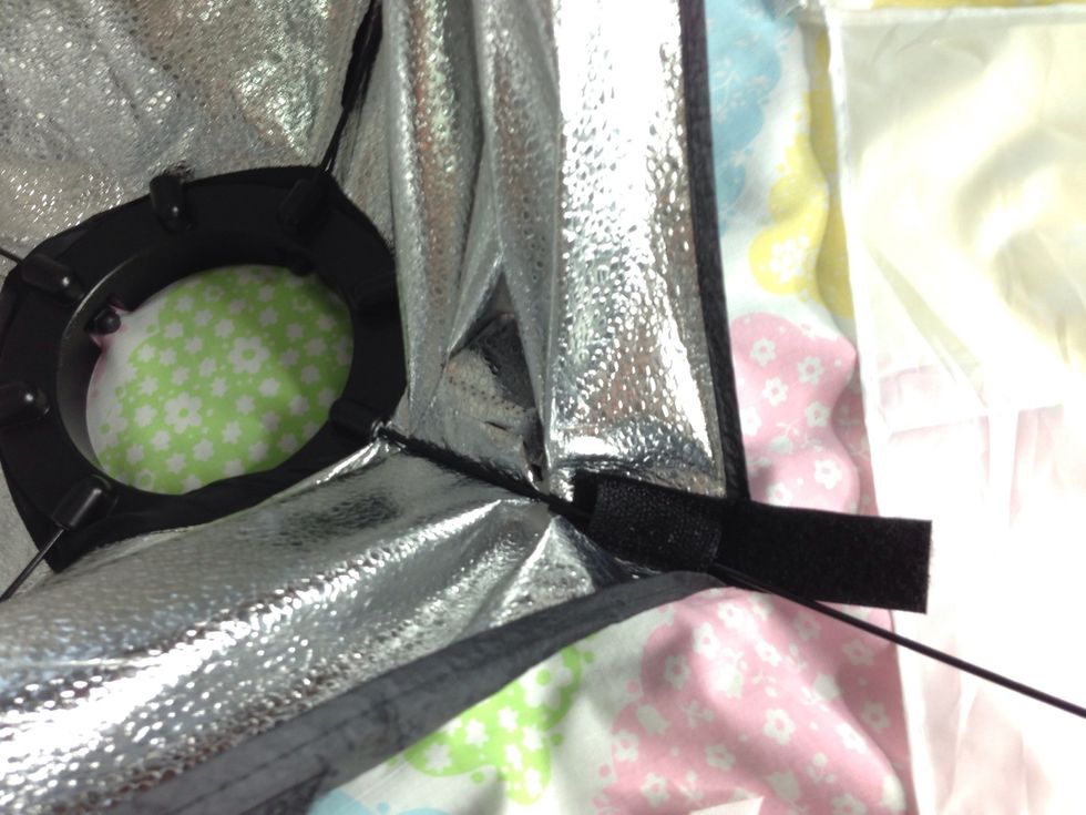 Indent the pin into the socket in the ring while folding the softbox material closer to the ring.