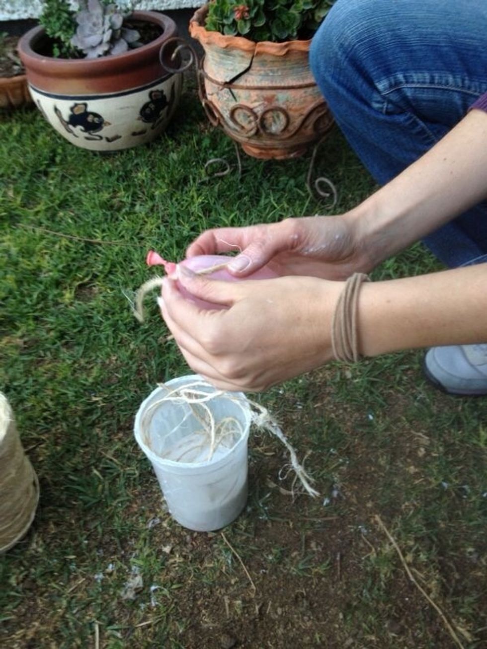 Inflar el globo del tama\u00f1o deseado. En el contenedor de pl\u00e1stico mezclar a partes iguales el pegamento blanco y el agua. Remojar la cuerda. / Blow the ballon, mix water and glue. Soak rope in the mix