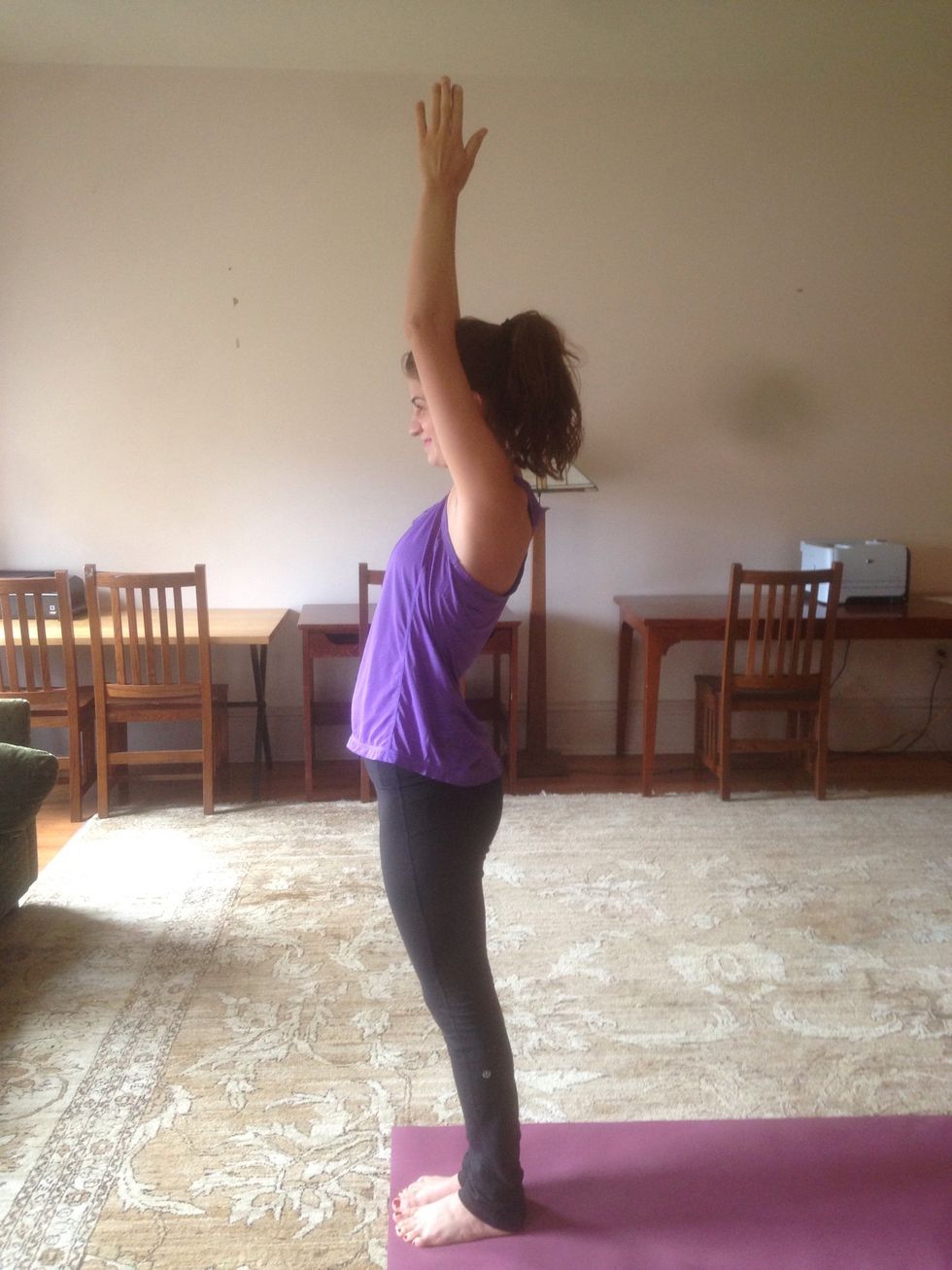 Inhale, and reach straightened arms above head. Lean backwards slightly to feel a stretch through the hips.