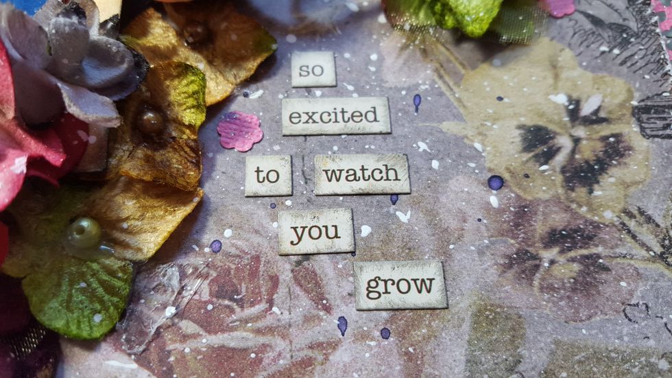 Ink the edges of the journal words and stick down. Add some of the small flowers saved from the punching, dotted around the flower clusters.