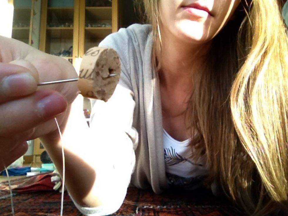 Insere your needle with your thread in the cork.