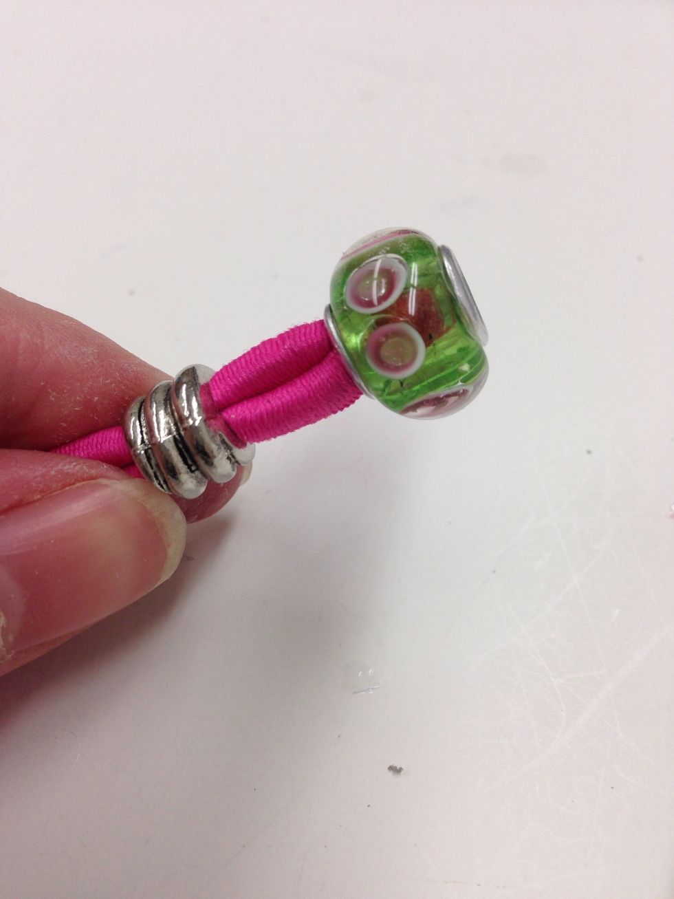 Insert 2 beads over the loop. You will need to twist the cord into the beads and use a t-pin to feed the cord through. Slide them up the cord until about 1/2" from the end of the looped piece.