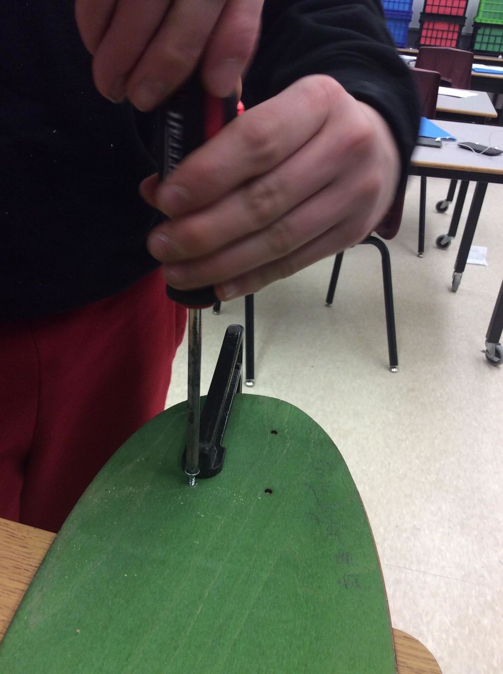 Insert a 3/4" #2 Robertson screw through the hole. Do NOT over tighten.