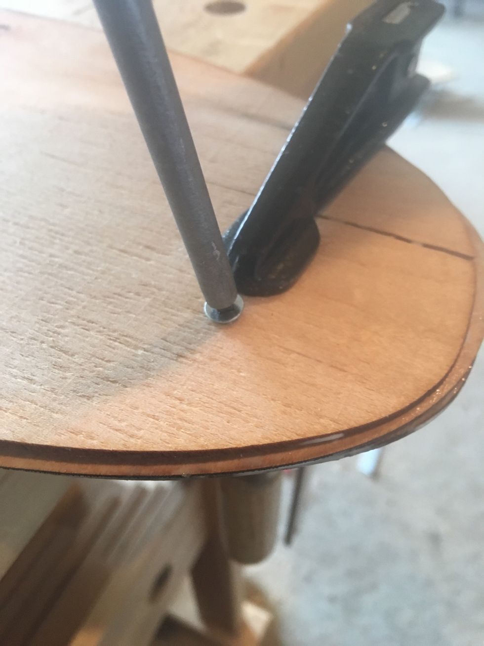 Insert a 3/4" #2 Robertson screw through the hole. Do NOT over tighten.