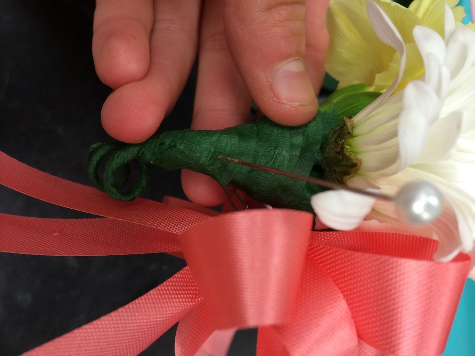 insert a pin in the side of the corsage so that you are able to pin it on to the person who will be wearing it.