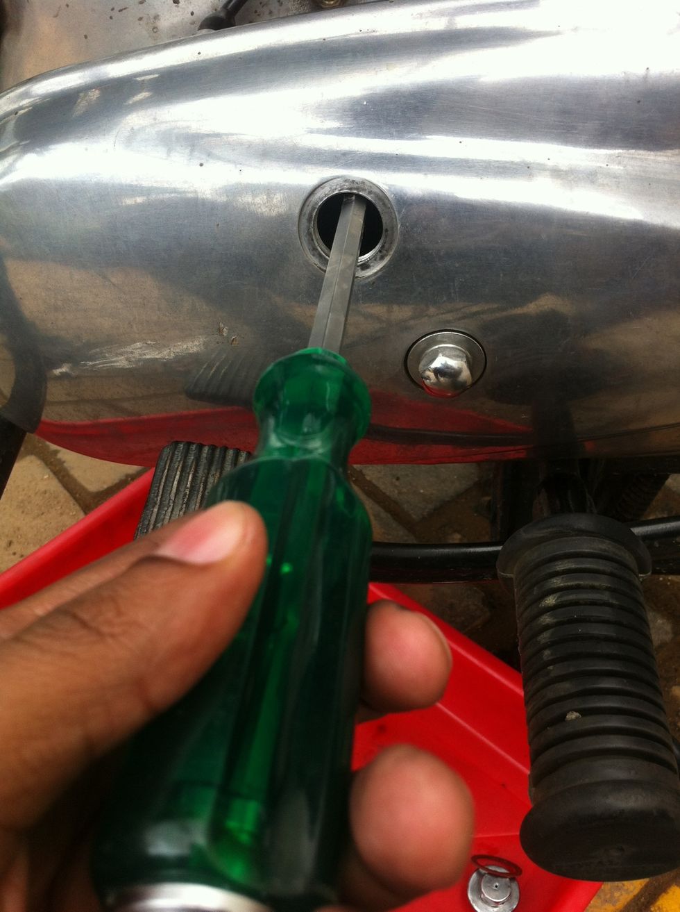 Insert a screw driver underneath the primary chain