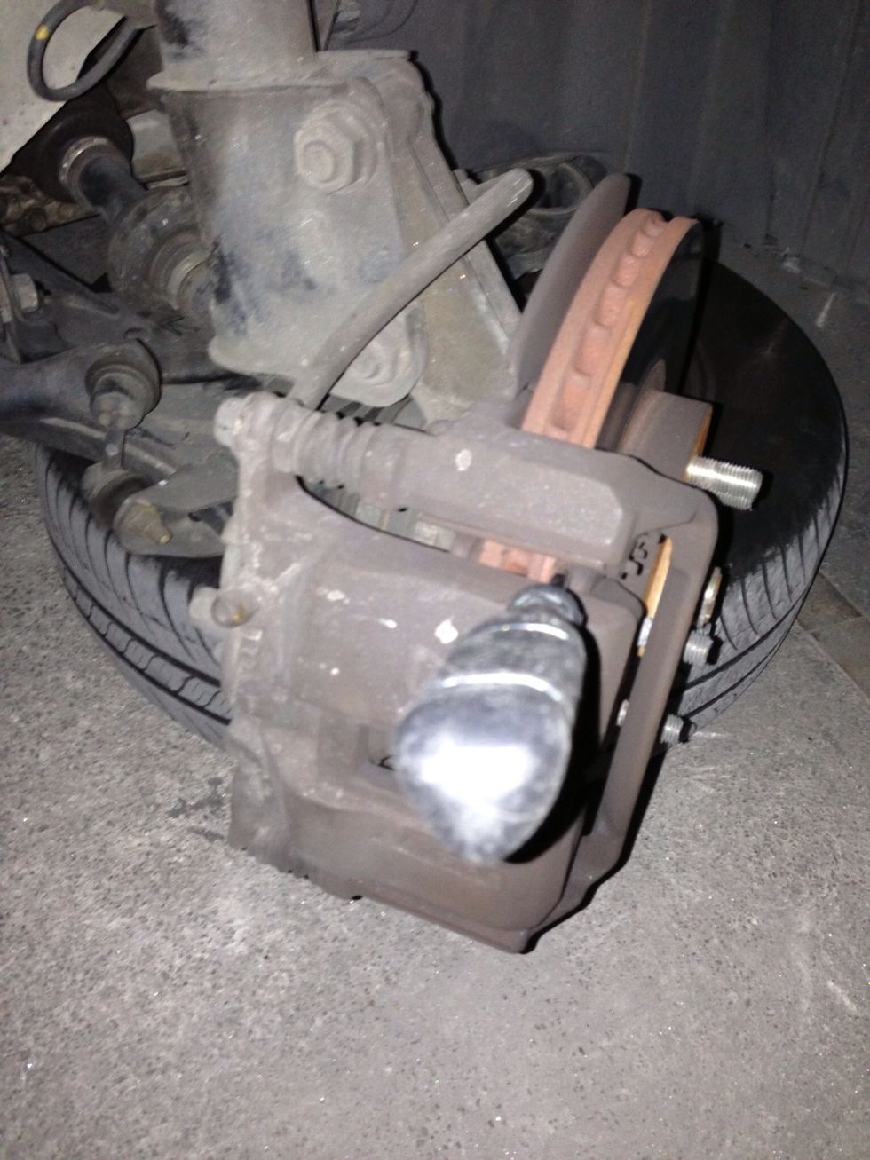 Insert a screwdriver and push it as a lever. Push the ridge of the pad out, then after there's more room slide it between pads and rotor. ALWAYS push away from rotor or you'll scratch it.