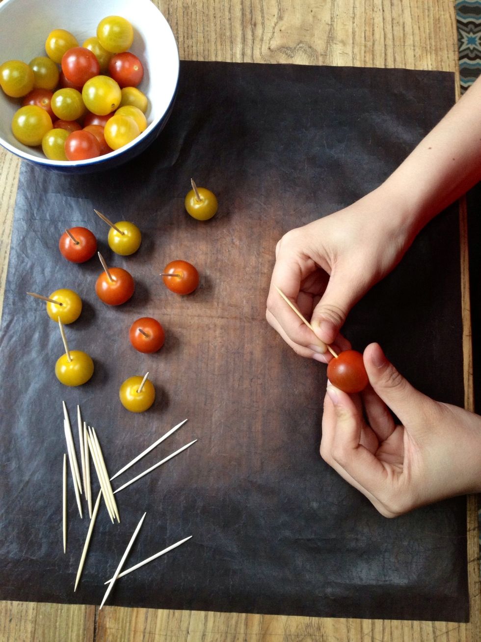 Insert a toothpick in each tomato stalks (after being washed and dried). The tomatoes must be perfectly dry (otherwise the caramel "squirt").