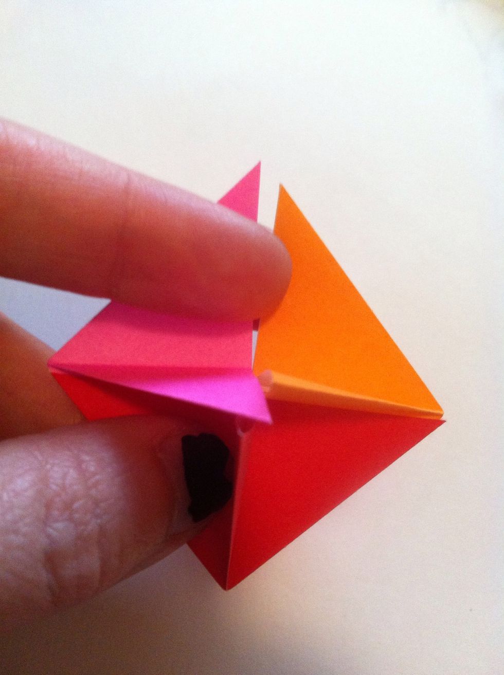 Insert another into opposite pocket. Red has filled two pockets opposite each other, so now it's other two parts become tips, not pockets. Only one set of pockets opposite each other for each color.
