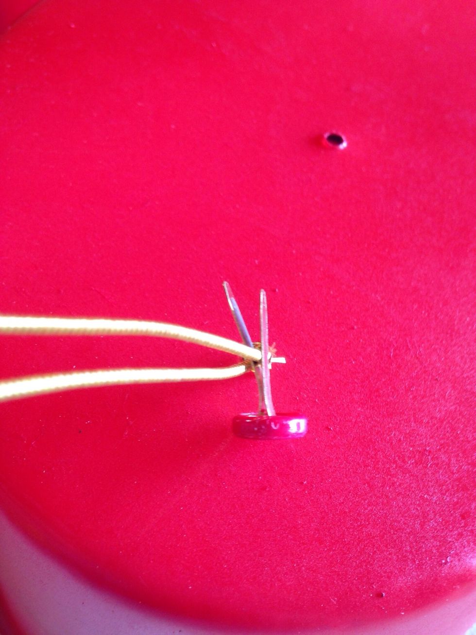 Insert brad between the loop of the band, one prong on each side of band.