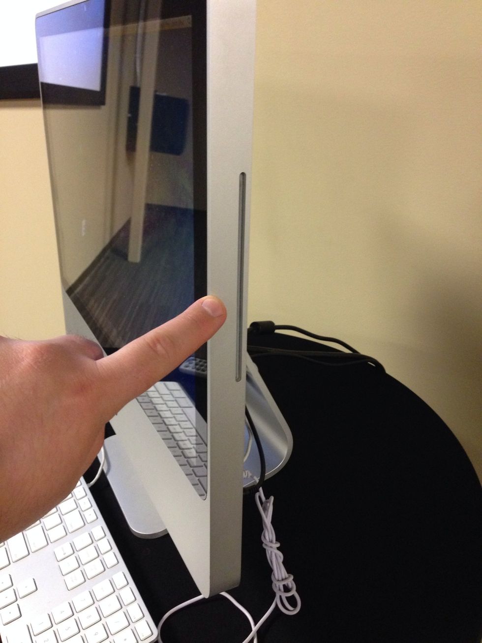 Insert DVD into the slot on the right side of the computer