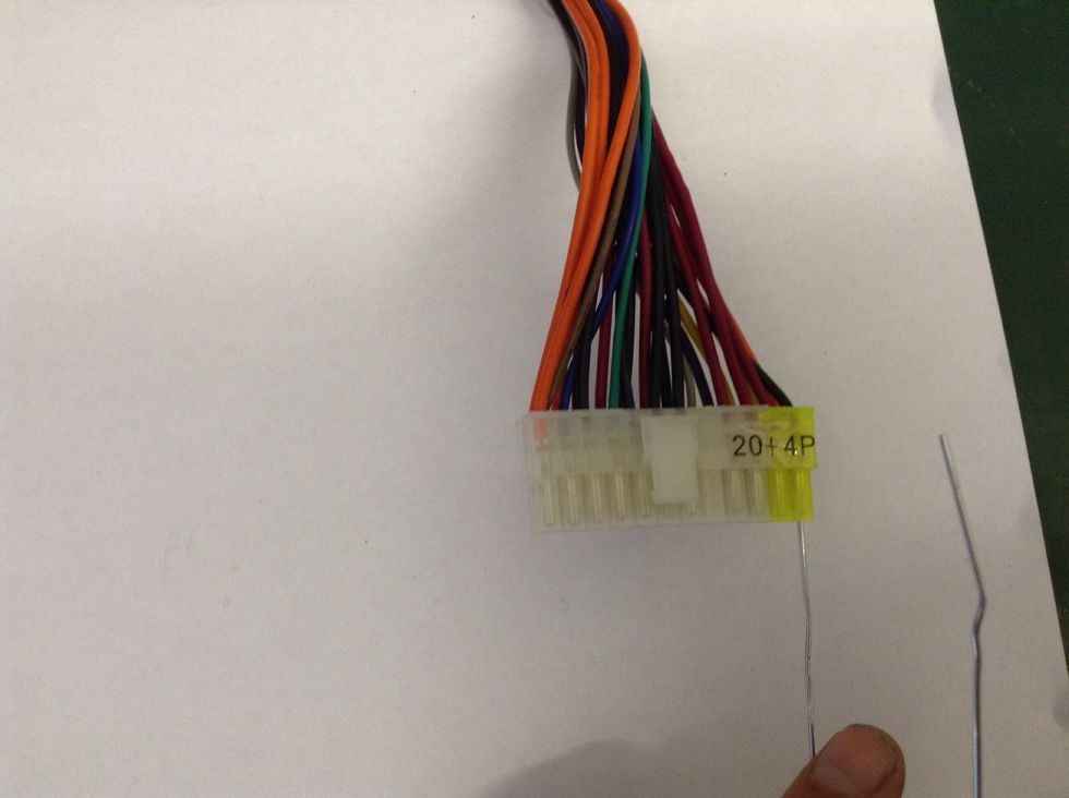 Insert one end of the paper clip into the bottom of the plug beneath the BLACK wire to the far right of the plug.