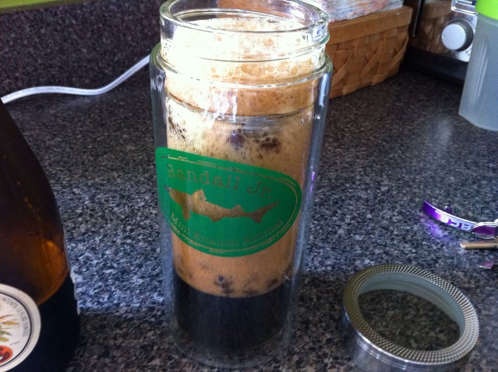 Insert strainer and pour beer over coffee beans.