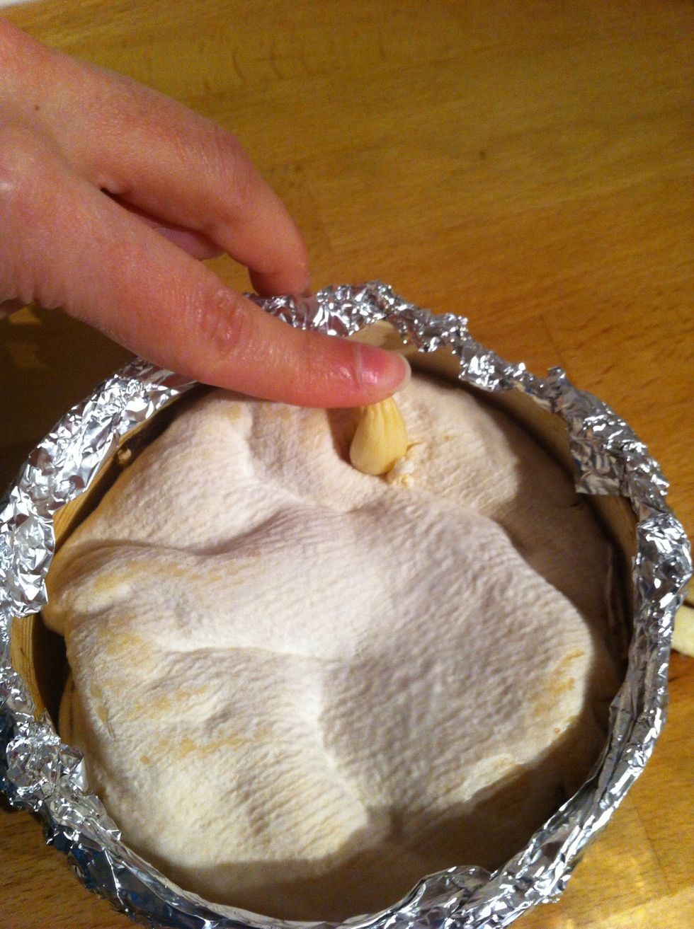 Insert the garlic clove into the small hole