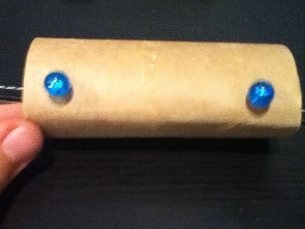 Insert the pushpins into the paper roll, so that they support it when you put your iPod into the dock.