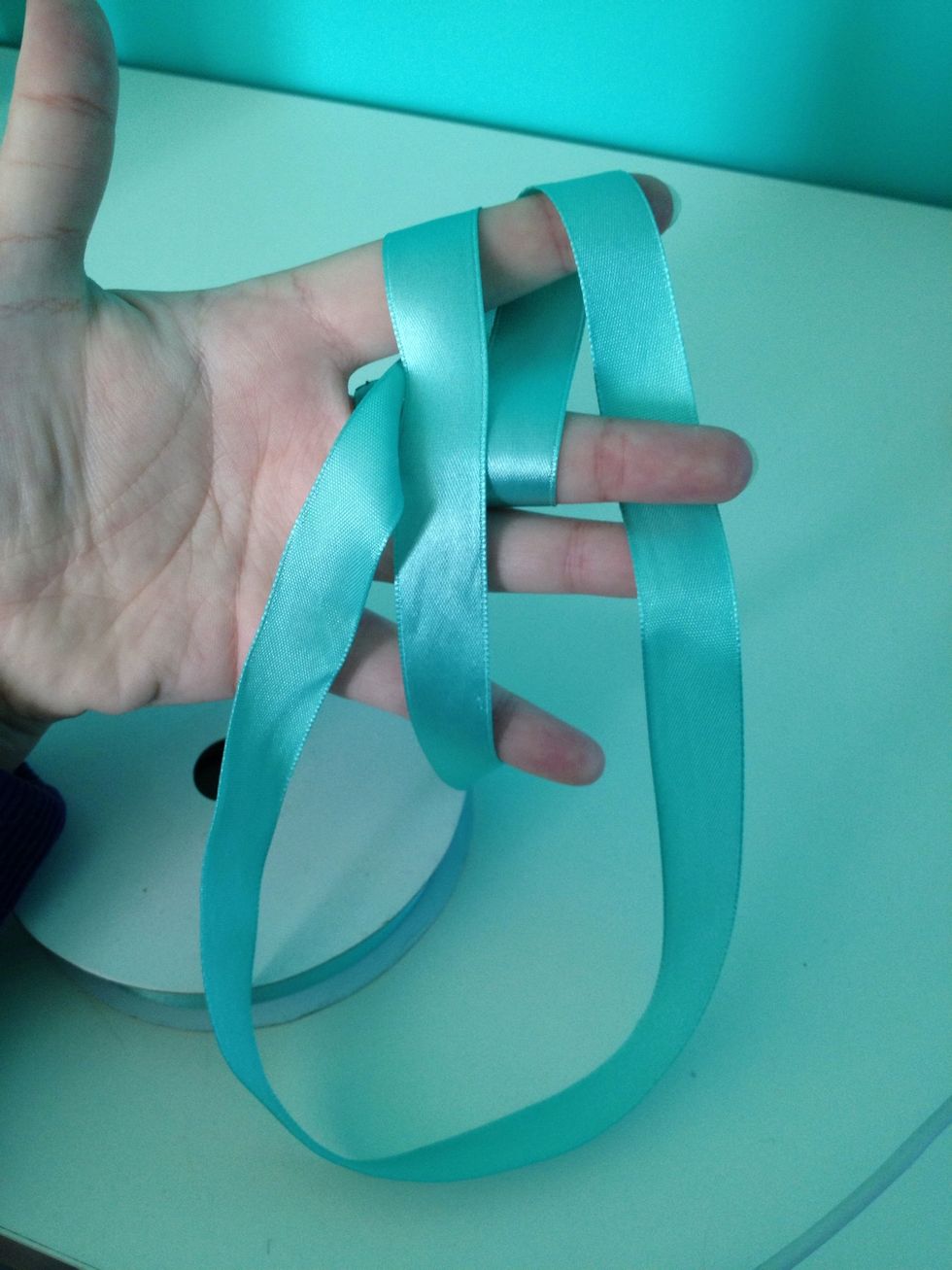 Insert the ribbon through the small gap in between your two fingers...