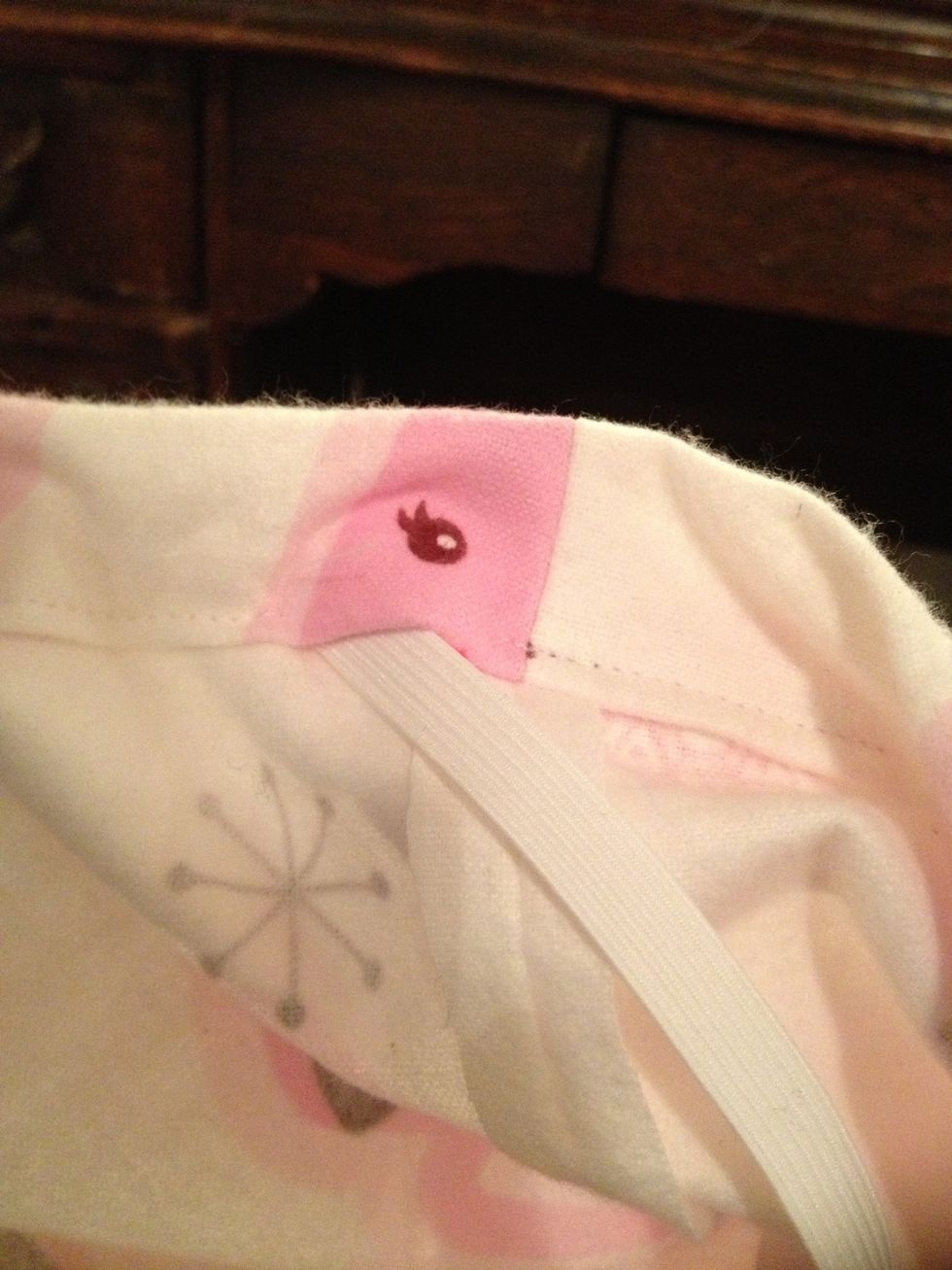 Insert the safety pin into the 1 inch hole that you left when you sewed the waist. Feed the safety pin through the waistband all the way until you get back to the hole on the other side.