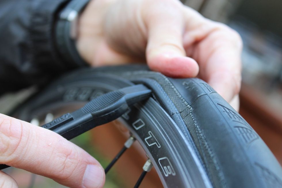 Insert the second lever into the same space and work it around the wheel to fully separate one side (and only one side) of the tire from the rim.