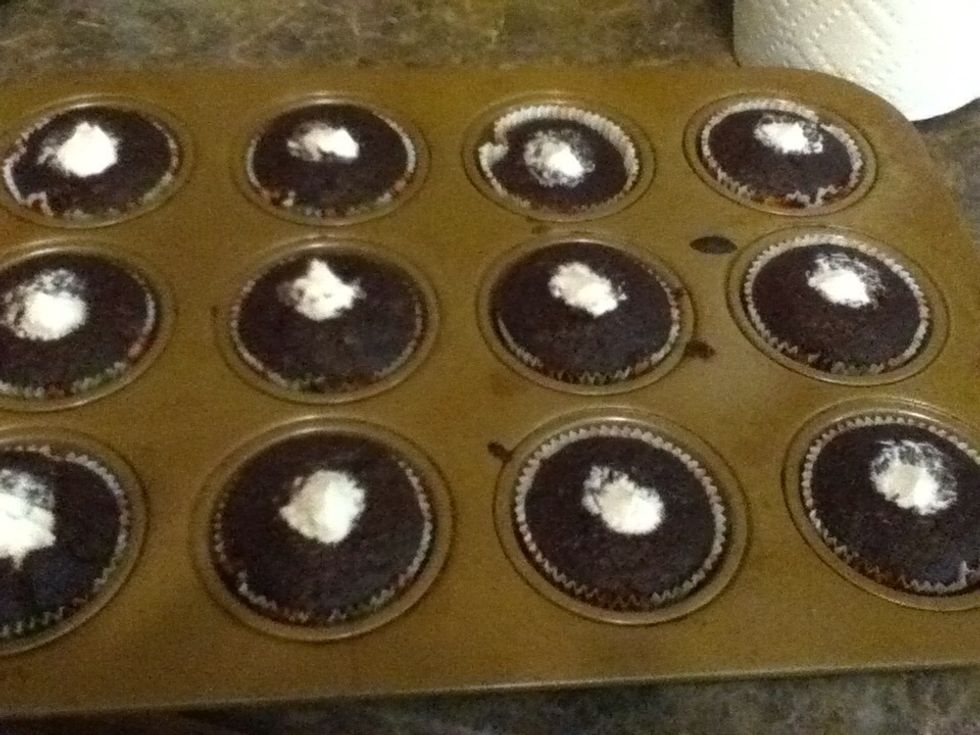 Insert the tip of the bag in the cupcake and squeeze. You'll see the cupcake expand when it's full. If you want a prettier presentation, smooth the tips out.