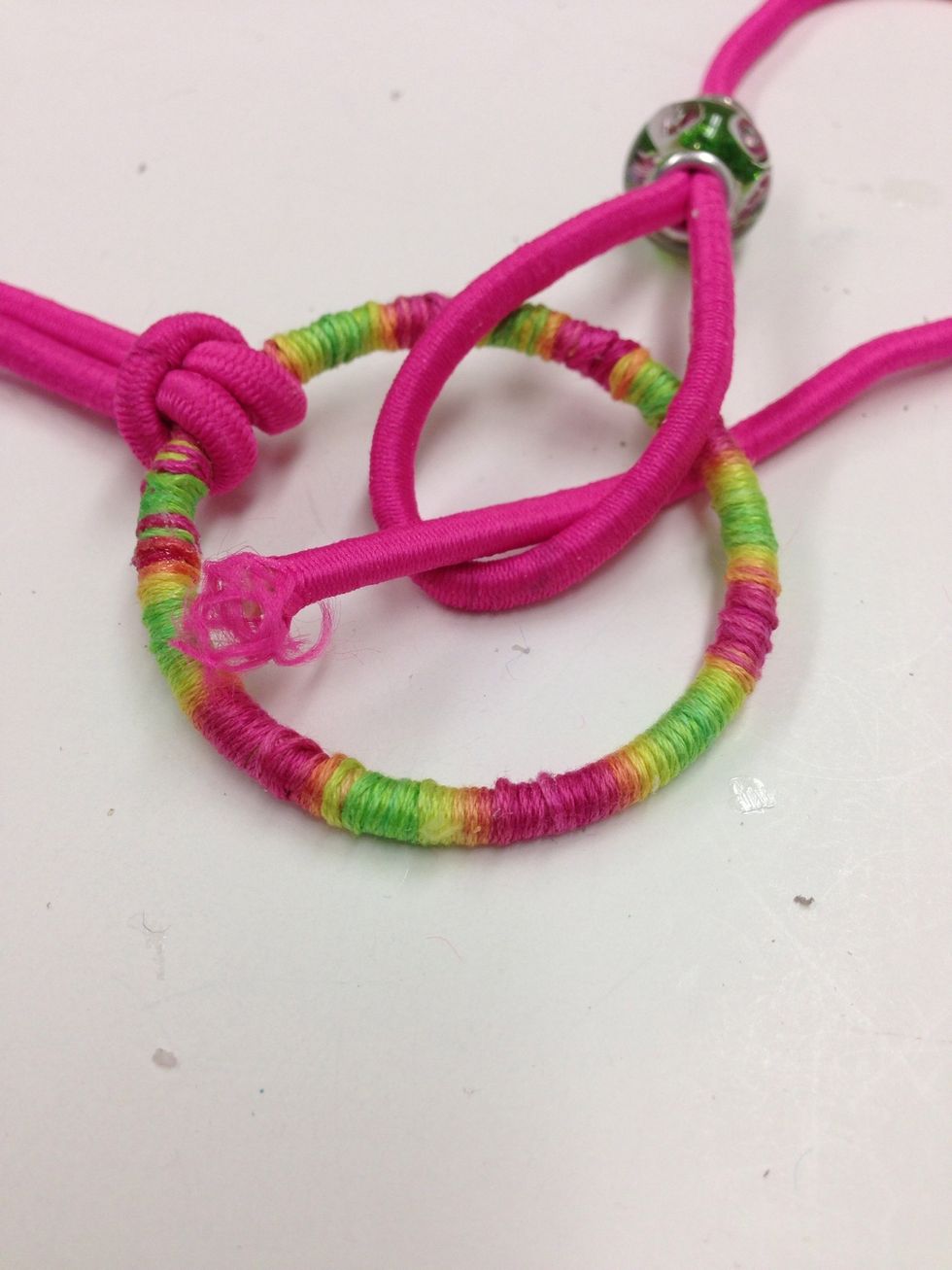 Insert the unfinished end of the cord under the ring and through the loop.