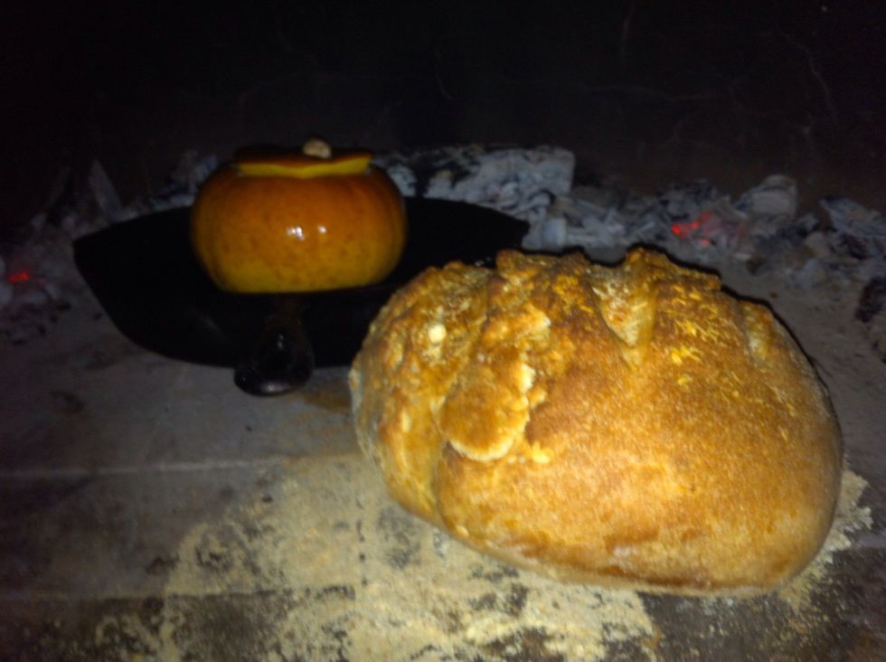Insert water-soaked wood oven door to help hold in & even out heat. After about 7-10 minutes bread is done. Our pumpkin took about 15-20 minutes. It's done when stuffing is firm & skin is caramelized.