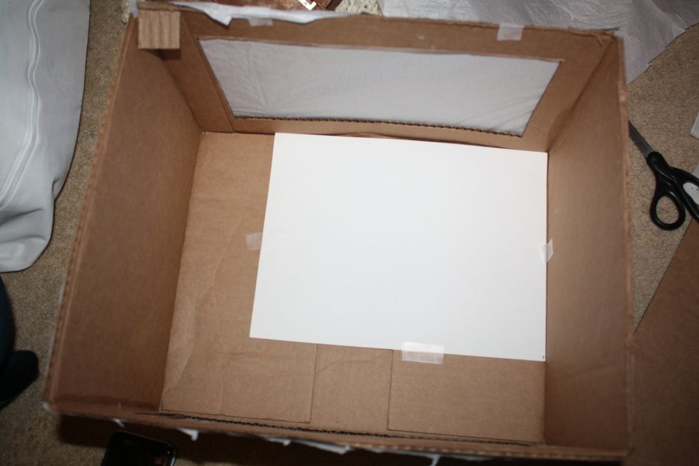 Insert white construction paper, or mat board into the box to fit the inside back and bottom