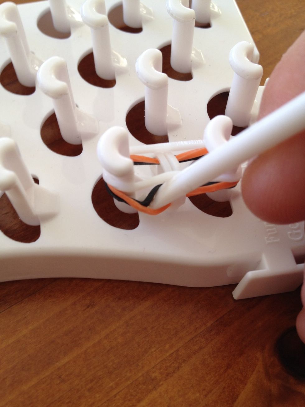 insert your hook I to the middle Of the second band on the pin and grab the bottom band and pull it up and over to the middle