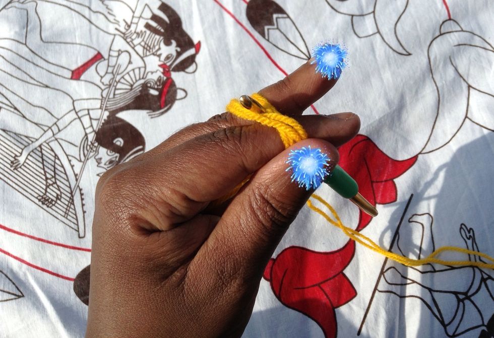 Insert your hook up and in between your index and middle fingers, and in between the tail and working yarn.