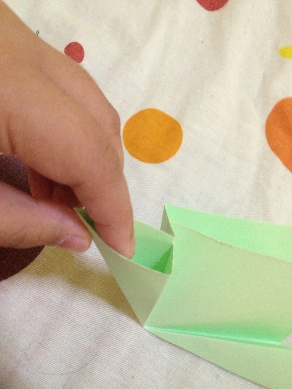 Insert your index finger in this side pocket, open then flatten it. Do the same to the other side pocket.