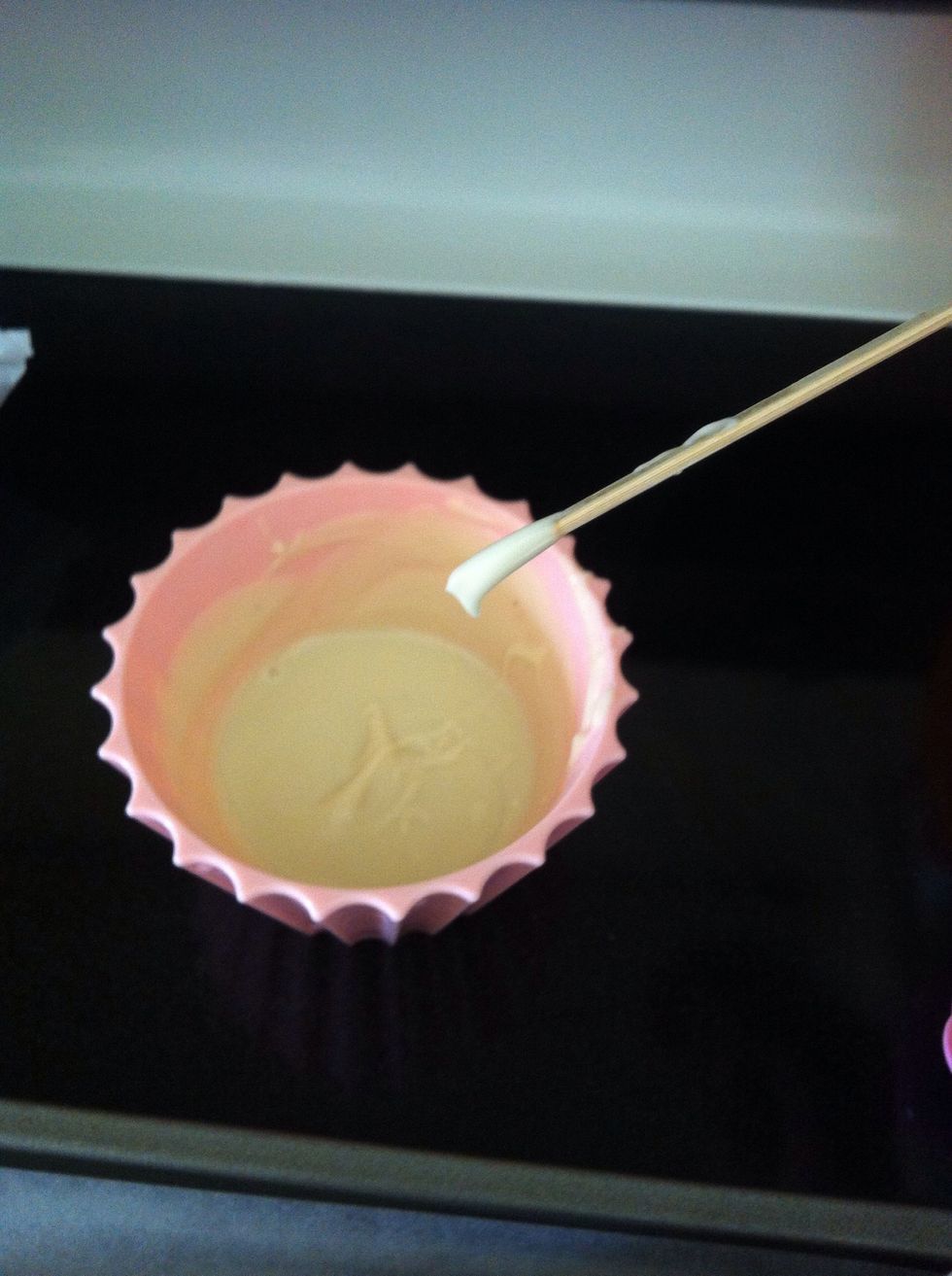 Insert your lollipop stick into the melted chocolate and then into the pops.