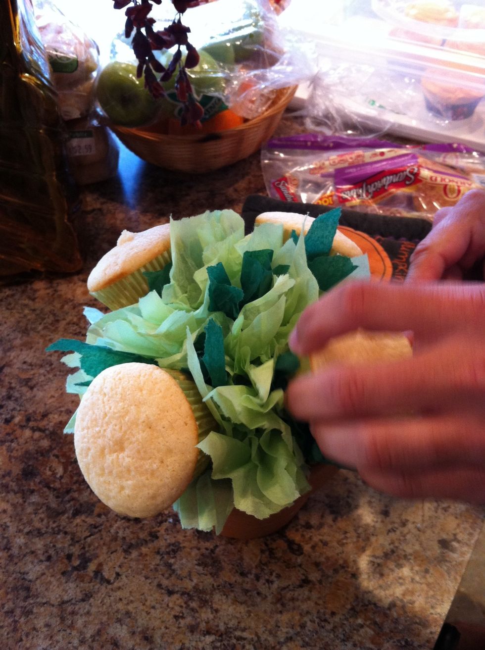 Insert your skewer into your styrofoam ball and insert your cupcake on the skewer. Add another skewer and repeat, adding regular size cupcakes and the minis