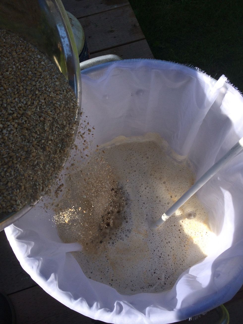 Insert your sparge bag and slowly stir in your grains and oats.REMINDER - grains must be milled at this point.The grains should reduce the temp to the desired mash temp. Do not use burner during mash.