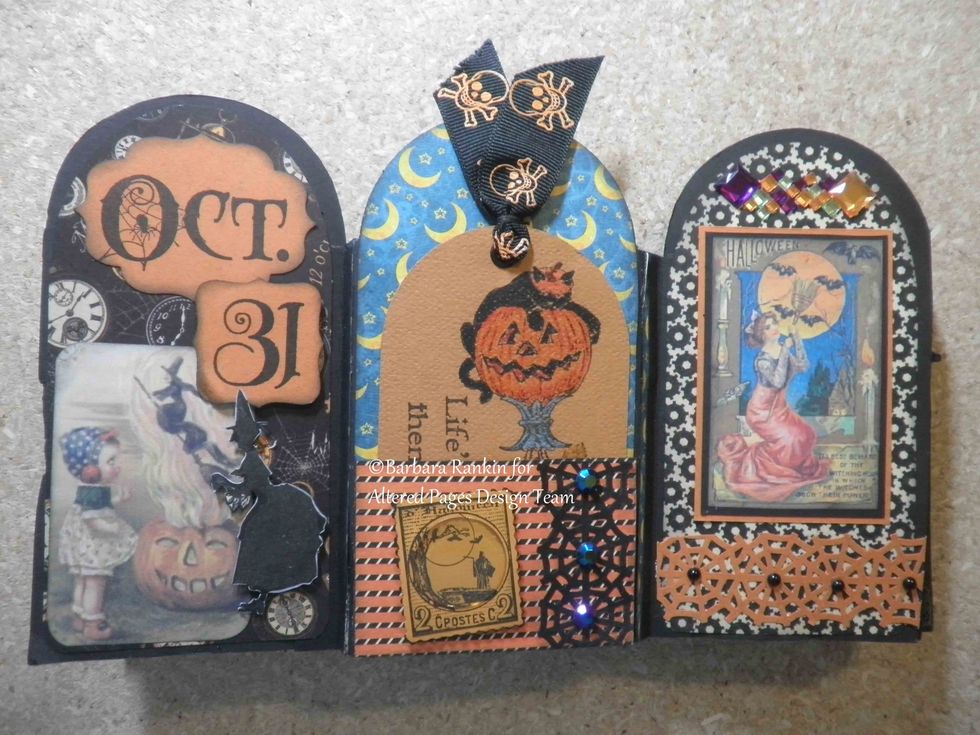 Inside center back panel. Small pocket made with G45 strip of paper to hold tag. Sin City Stamps Halloween postage stamped onto light orange CS in black, acrylic bubble over center, punched web.