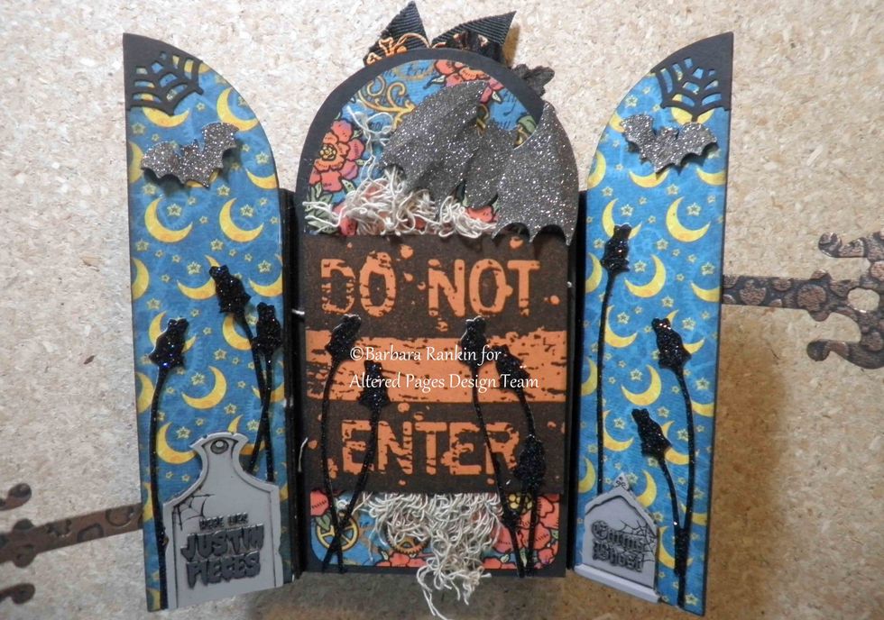 Inside cover and page 1: Sin City Stamps Do Not Enter stamped onto orange CS with black ink, creepy cloth, punched bats, spiderweb corners, die cut black roses, Stickles glitter, tombstone stickers.