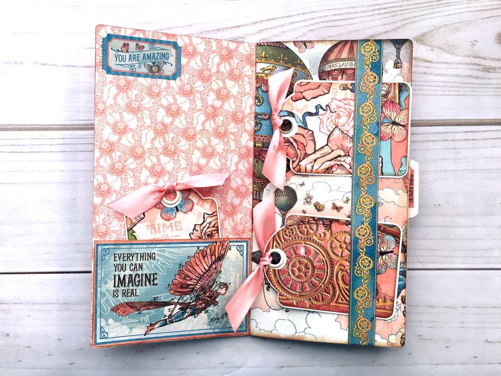 Inside cover, trim cut-apart from Castles in the Air to 4 1/8 x 2 1/8".  Apply thin glue line to bottom and sides of cut-apart & adhere to page bottom forming a pocket.  Add sticker ticket at the top.
