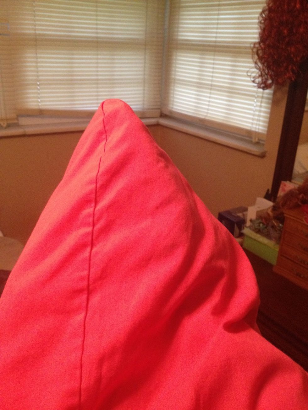 Inside of the pillow case, grab the other corner of the pillow and shove it to the second corner of the pillow case.