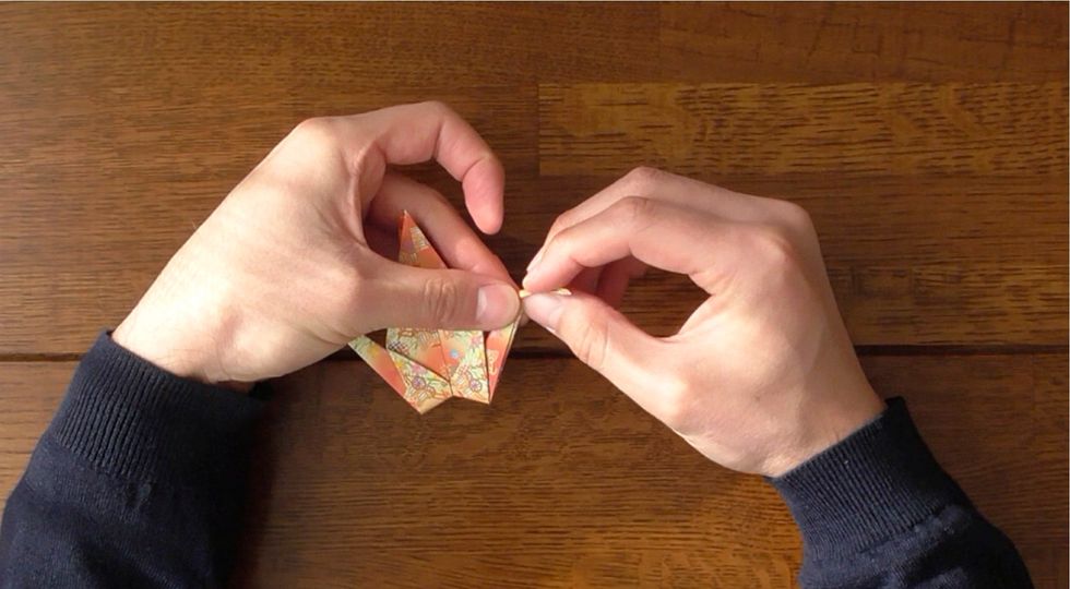 Inside- reverse fold right point up.  Inside-reverse fold left point to form head.
