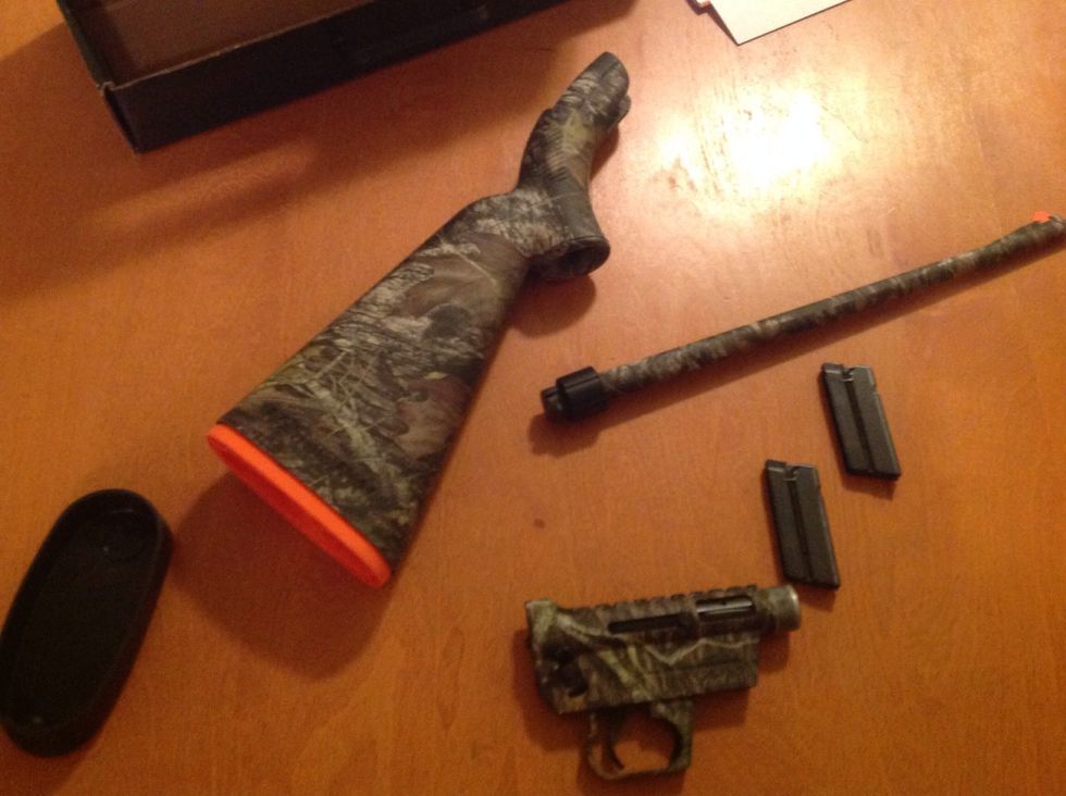 Inside the stock of the rifle you will find four parts. The receiver, the barrel, and two magazines. Remove them from the stock and set them off to the side.