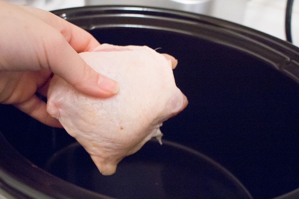 Into the slow cooker, place your chicken thighs