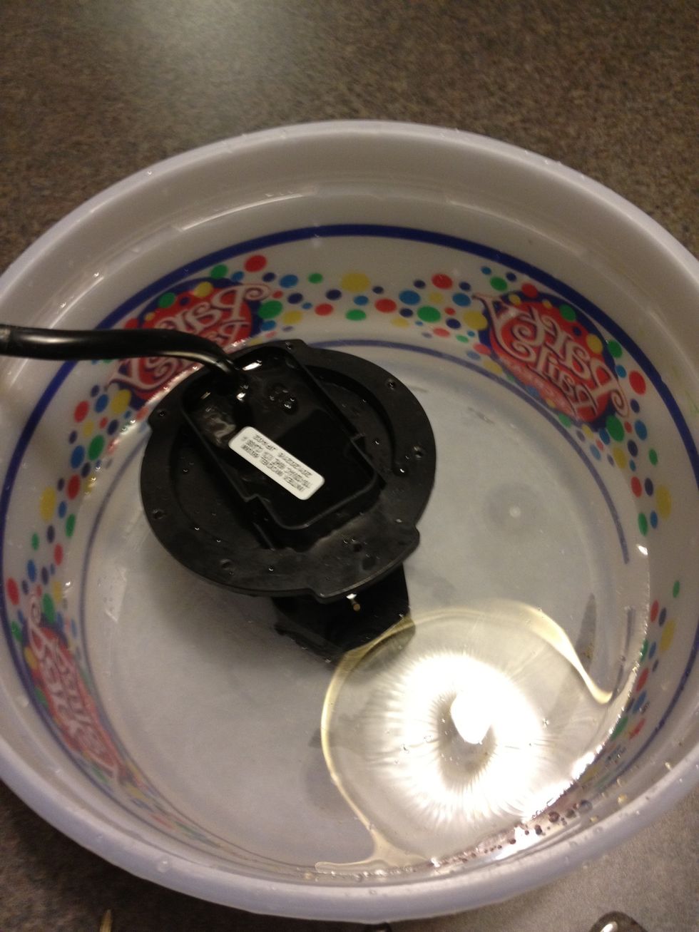 Invert the motor and partially submerge it in a bucket of water. Do not cover the motor completely. Run the pump to clear sand. Watch for splashing! And to be safe just hold a dry part of the cord.