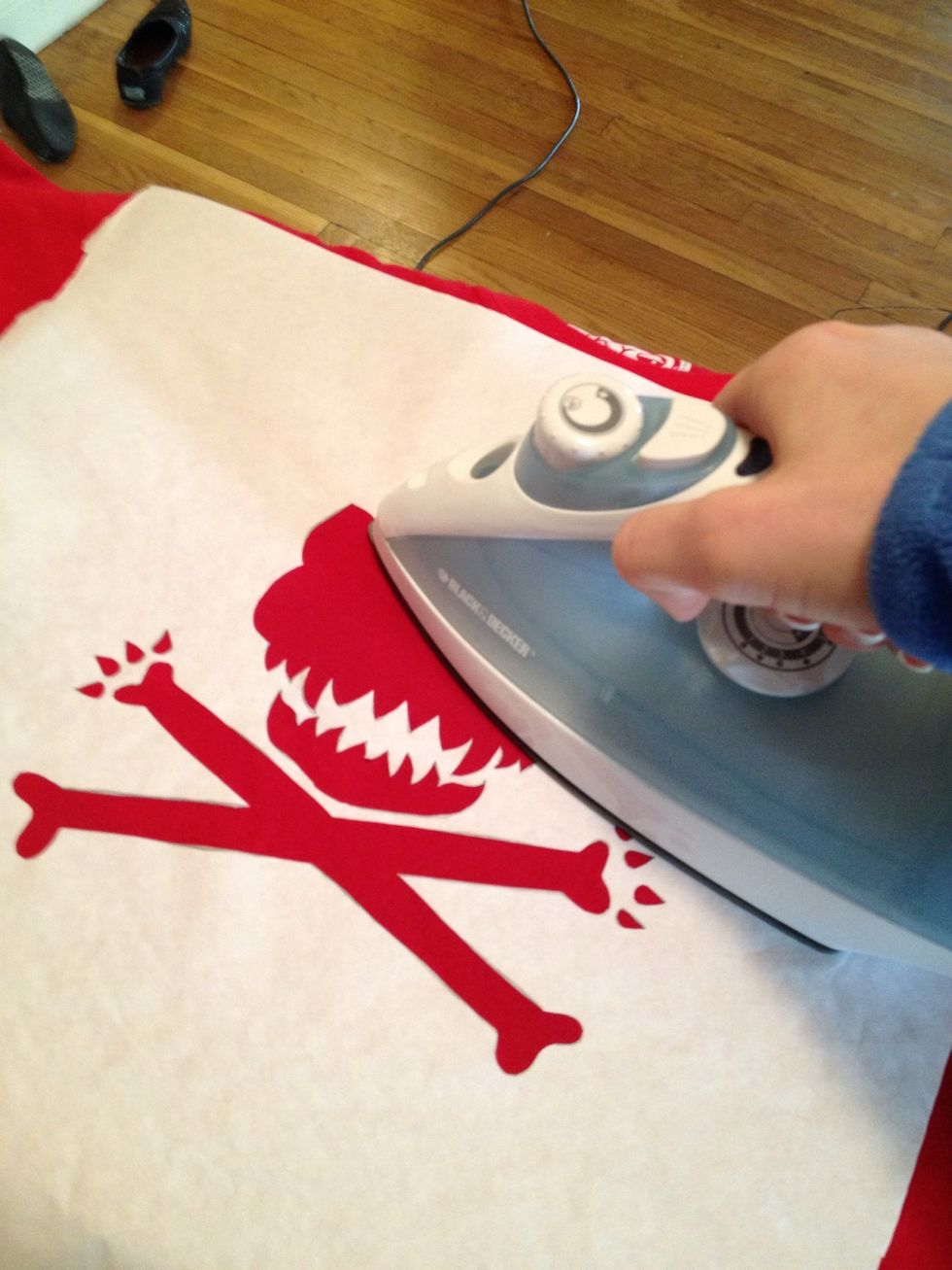 Iron out your shirt to get rid of wrinkles. Then position your stencil (wax side down) on the shirt and iron it flat.