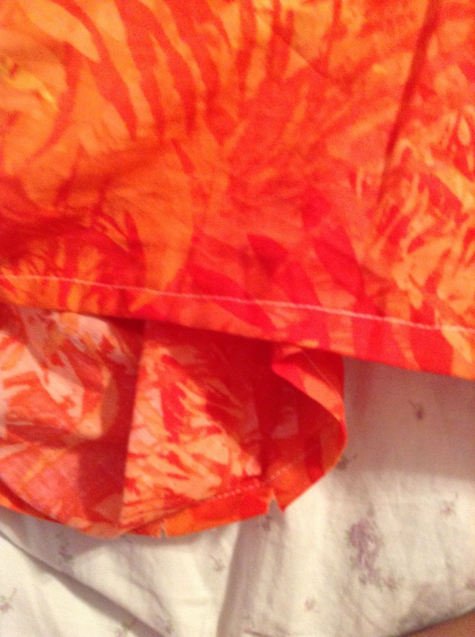 Iron the dress' hem. Then neatly stitch all the way around