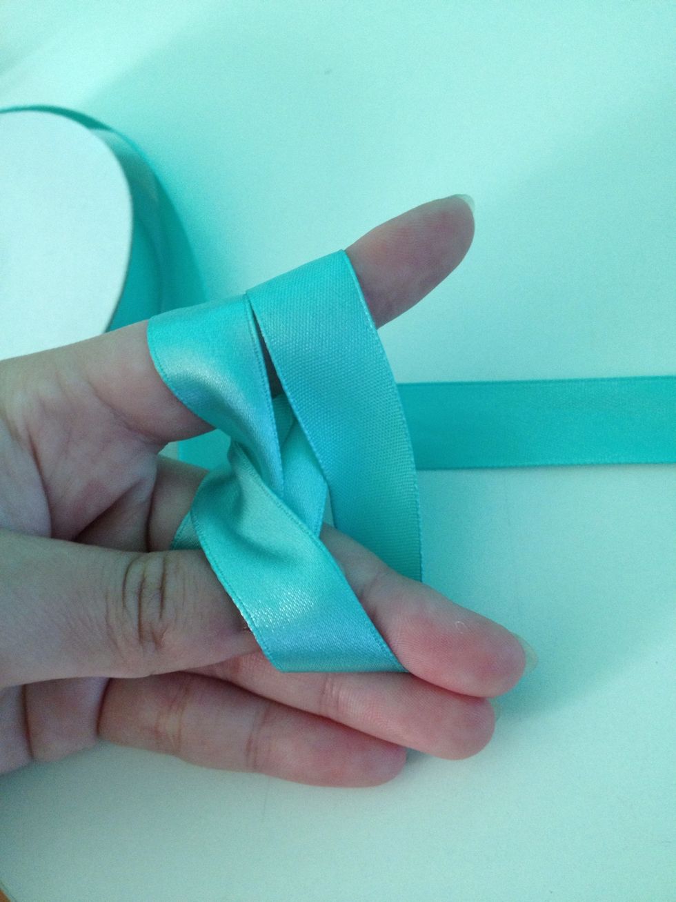 It helps to keep your thumb in between the strands to create a loop (you'll see why next).