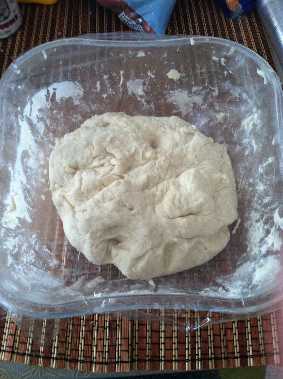 It will be a little sticky, so sprinkle a tbs of flour while mixing still. It will turn into a ball like this. Cover with plastic wrap and set aside for an hour to let rise.