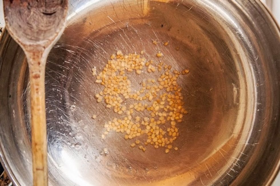 It will start to turn rosy gold. When it does, add in the mustard seeds.