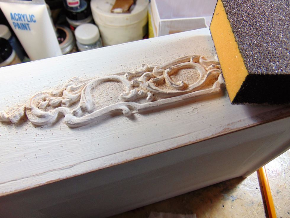Its sanding time. With a sanding block gently rub away some of the white acrylic paint on the raised details to reveal the beige paint underneath, thus creating the shabby, worn look.