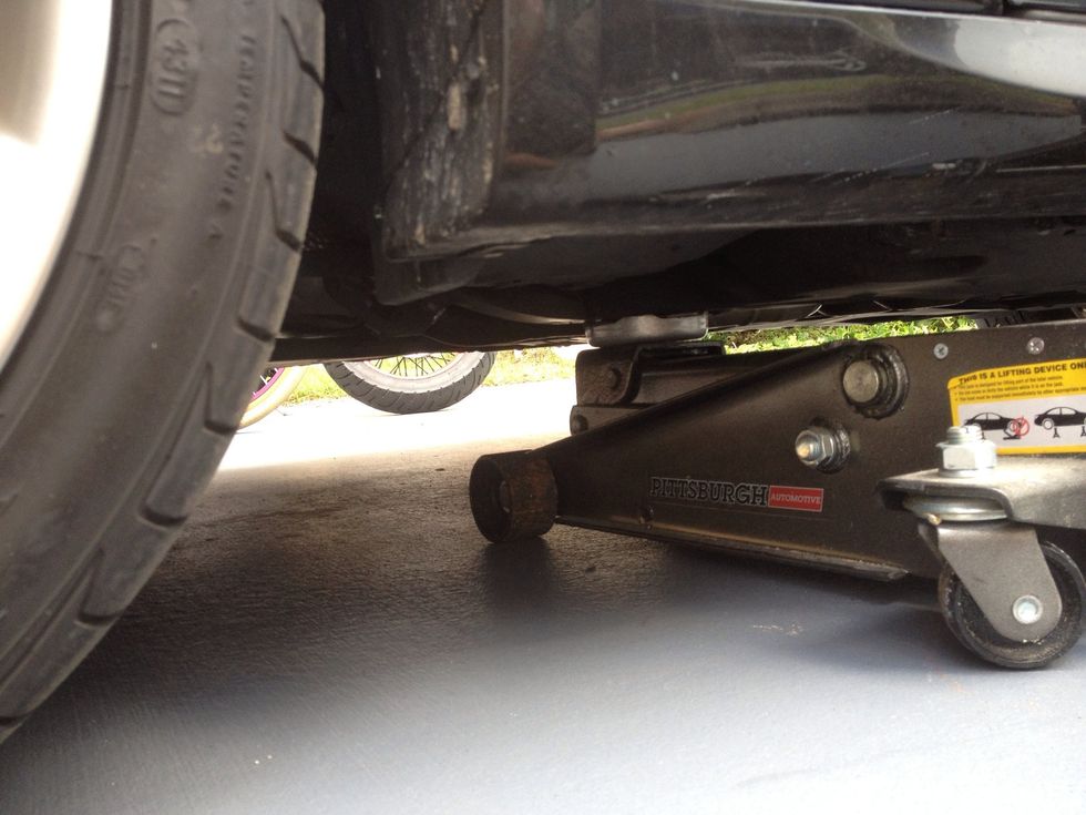 Jack the car up on the drivers side, using a jack point, or using the frame rail